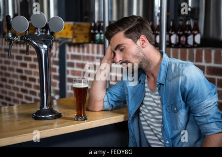 Tired man leaning on counter Stock Photo