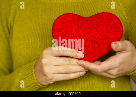 Closeup on red heart made from wool in hand of woman. Image of Valentines day Stock Photo