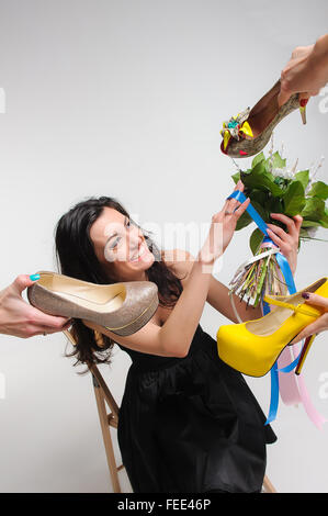 Girl in black dress chooses shoes for his wedding Stock Photo