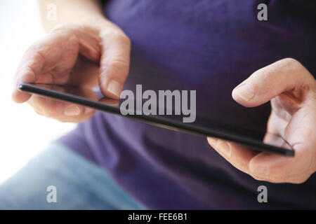 A senior man uses his new tablet. Stock Photo