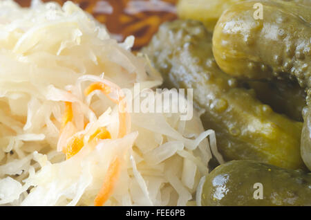 pickled cucumbers and sauerkraut in brine on table Stock Photo