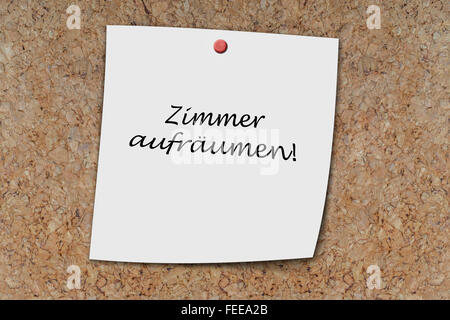 Zimmer aufräumen (German clean up room) written on a memo pinned on a cork board Stock Photo