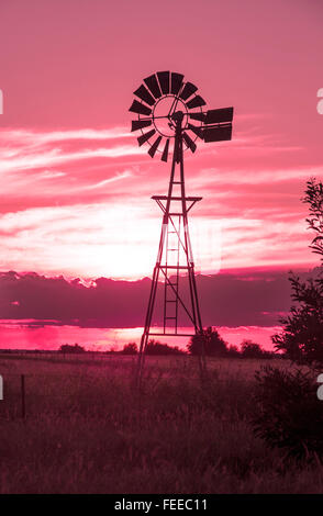 Windmill at sunset on country bush outback farm Queensland Australia Deep red filter Stock Photo