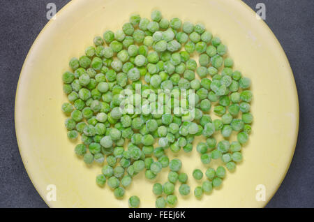 frozen green peas on plate Stock Photo