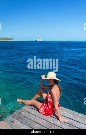 Woman sitting on jetty, Tetamanu, Fakarava, Tuamotu Islands, French Polynesia Stock Photo