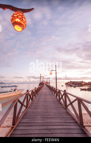 Image of Long Jetty in  Mabul Island Semporna, Sabah with calm water and blue sky background. Stock Photo