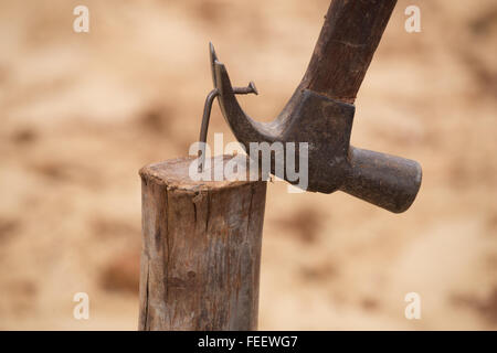 hammer pulling a nail out of wood at construction site Stock Photo