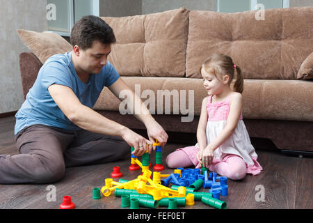 father and daughter building a ball slide tower Stock Photo