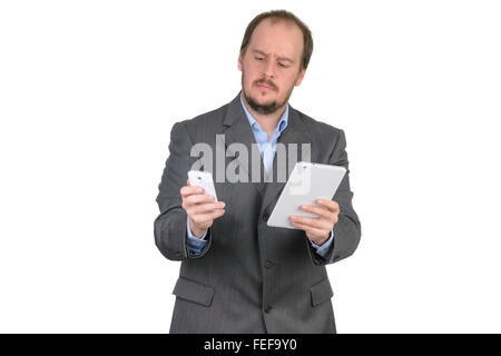 man in suit confused choosing tablet computer or cellphone mobile phone Stock Photo