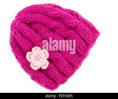 Pink wool knitted winter hat with a small crochet flower motifs, Hand knitted, On a white background Stock Photo