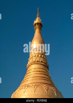 Top of the gilded stupa of Shwedagon Zedi Daw Pagoda and its ornamental Hti, or crown umbrella ornament. Yangon, Myanmar. Stock Photo