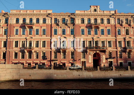 Beautiful brick canal-side sun drenched buildings on the Moyka River in St Petersburg, Russia. Stock Photo