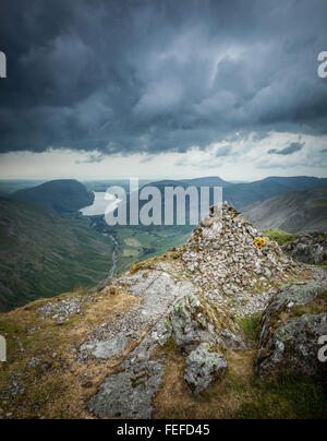 Looking up Wasdale valley to Wastwater in the distance from the westmorland cairn on great gable with a very moody stormy sky. Stock Photo