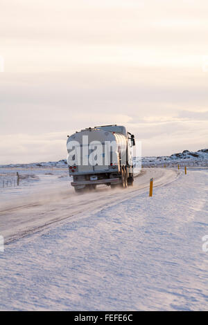 Tanker driving along road through snow covered mountains in Iceland in February Stock Photo