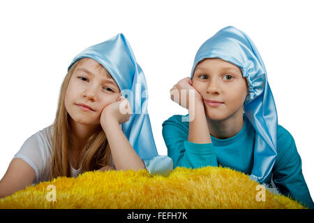 Cute boy and girl in pajamas and blue sleeping hats isolated on white Stock Photo