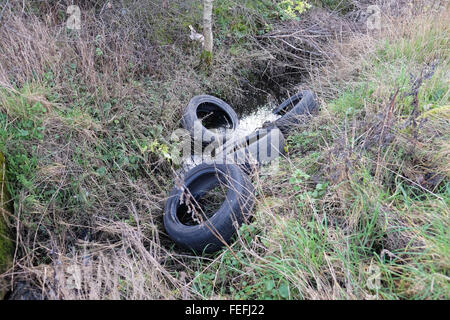 tyres dumped in a ditch Stock Photo