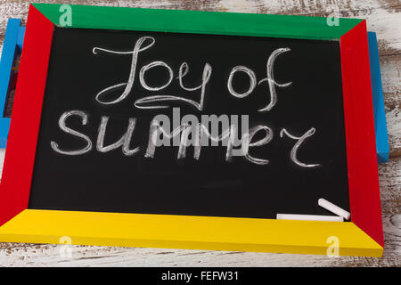 Blackboard with text it's Joy of summer on wooden deck Stock Photo