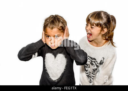 Eight year old girl being angry and shouting at her sister. Isolated on white. Stock Photo