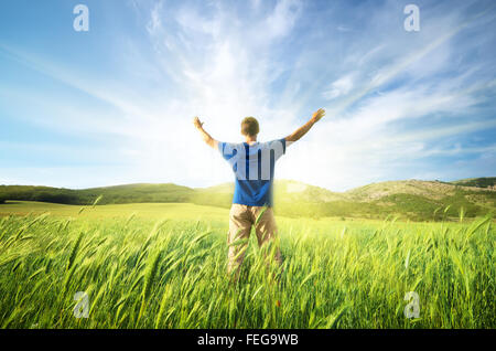 Man in green meadow of wheat. Emotional scene. Stock Photo
