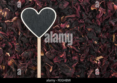 Pointer in the form of heart lies on dried hibiscus, with space for your text Stock Photo