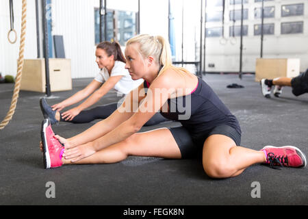 Two women stretching at the fitness gym Stock Photo