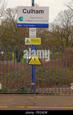 A series of signs mounted on a post adjacent to a platform stating 'Culham' along with warning signs. Stock Photo