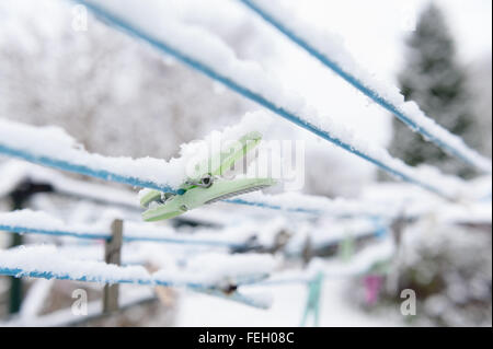Row of old new wooden plastic clothes pegs on a washing line with out of focus background ready for washing a daily chore Stock Photo