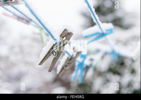 Row of old new wooden plastic clothes pegs on a washing line with out of focus background ready for washing a daily chore Stock Photo