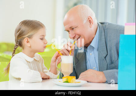 Enjoying a drink with grandfather. Stock Photo