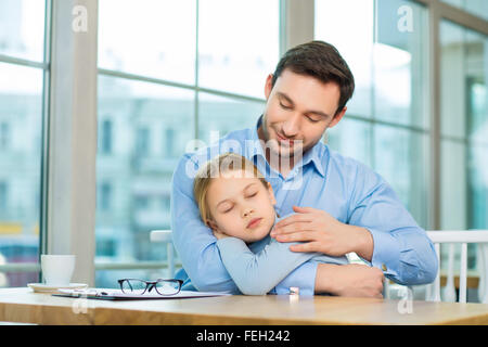 Handsome man holding his sleeping daughter Stock Photo
