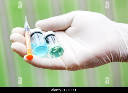 Hand holding a syringe with two vials Stock Photo