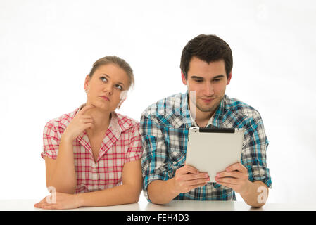 young couple wearing checked shirts, using tablett pc Stock Photo