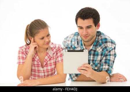 young couple wearing checked shirts, using tablett pc Stock Photo