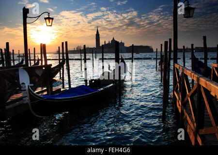 Looking across to San Giorgio Maggiore with moored gondolas in Venice at sunrise Stock Photo