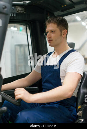 Forklift operator working in the warehouse. Stock Photo