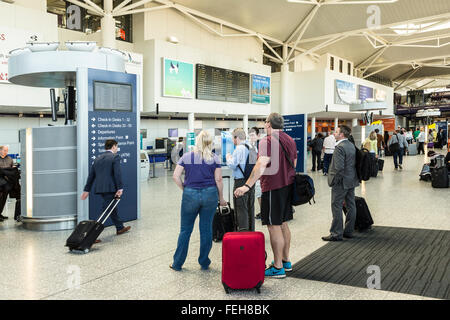 Passengers reading sign for check in desks and departures at Bristol airport, England, UK Stock Photo