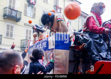 Ivrea, Italy. 07th Feb, 2016. Orange throwers on foot without any protection, throw oranges toward orange throwers on horse-drawn carts wearing protective masks reminiscent of ancient armor battle . © Mauro Ujetto/Pacific Press/Alamy Live News Stock Photo