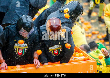 Ivrea, Italy. 07th Feb, 2016. Orange throwers on foot without any protection, throw oranges toward orange throwers on horse-drawn carts wearing protective masks reminiscent of ancient armor battle . © Mauro Ujetto/Pacific Press/Alamy Live News Stock Photo