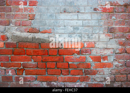 Red brick wall with part coverd with plaster Stock Photo