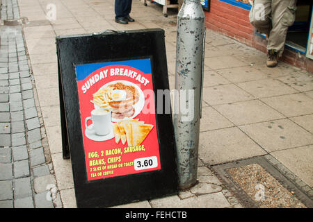 Board outside café in Walthamstow, North-East London, displaying a 'Sunday Breakfast', with full English breakfast pictured. Stock Photo