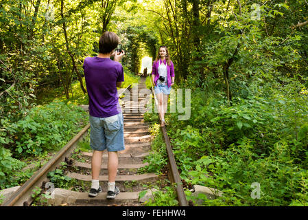 Tourists taking photographs in the Tunnel of Love - a natural tunnel formed in the forest, Klevan, Rovno Region, Ukraine Stock Photo