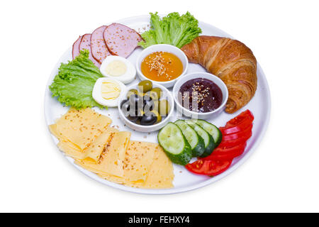 Plate of breakfast with croissant, boiled egg, meat and cheese in big white plate, isolated with clipping path Stock Photo