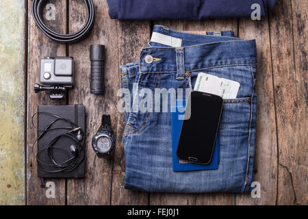 Mock up of summer travelling stuff on wooden board. Smartphone, documents, waterproof watch, torch and action camera Stock Photo