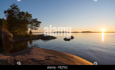 Sunset at small bay on the rocky coast of the island Yxlan in the archipelago near Stockholm, Sweden Stock Photo