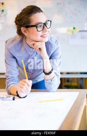 Inspired beautiful young business woman in glasses working in office Stock Photo