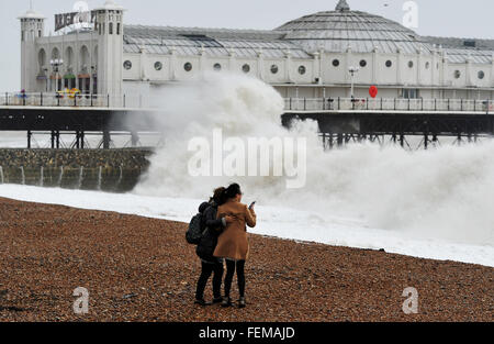 Brighton, UK. 8th February, 2016. UK Weather: These young women try to take a selfie photograph on Brighton beach as Storm Imogen batters the south coast today with the weather forecast predicting wind speeds of up to 90 mph causing widespread flooding and damage  Credit:  Simon Dack/Alamy Live News Stock Photo