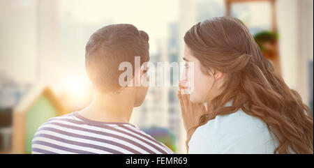 Composite image of woman whispering secret to boyfriend Stock Photo