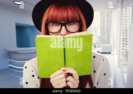 Composite image of hipster woman behind a green book Stock Photo