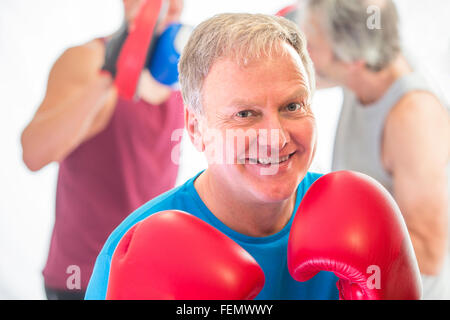 Senior man posing posing in a fighting stance with boxing gloves Stock Photo