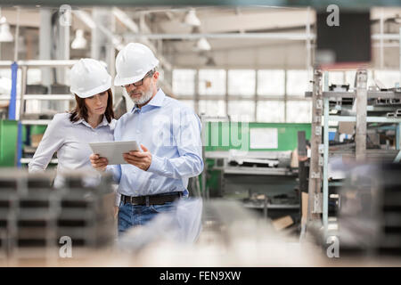 Engineers using digital tablet in steel factory Stock Photo